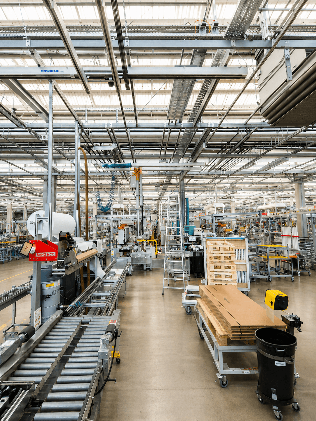 Industriehalle mit Fördertechnik, Steigleiter und Palettenregalen im Prüfkontext